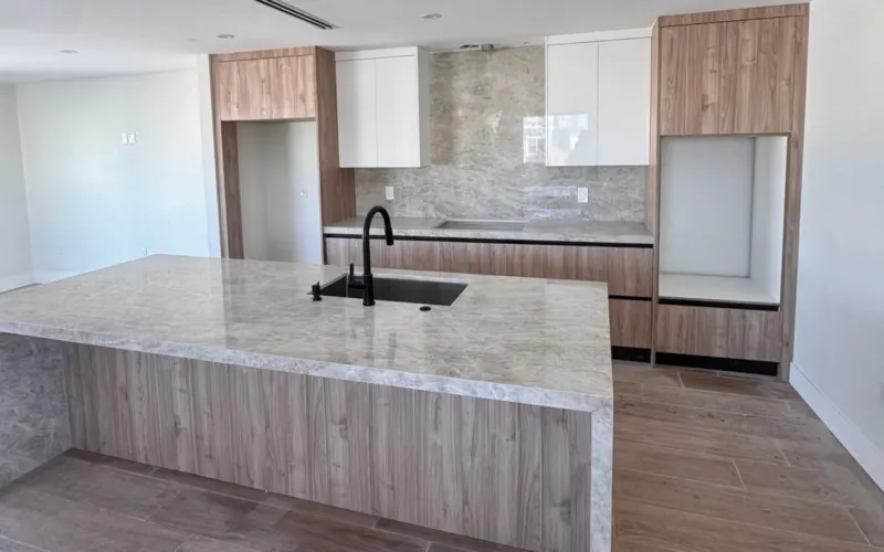 Kitchen 2: island with sink and black faucet, wood towers