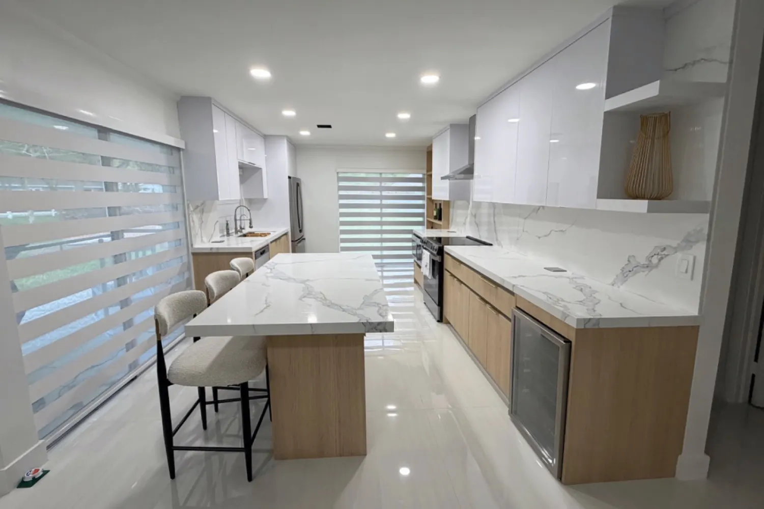 Kitchen 1: light wood and high-gloss white, with an island and light veined surfaces