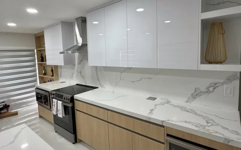 Kitchen 1: light veined countertop and backsplash under white cabinets